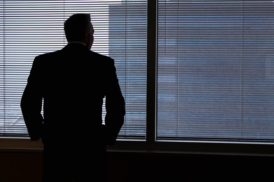 a man standing at an office window