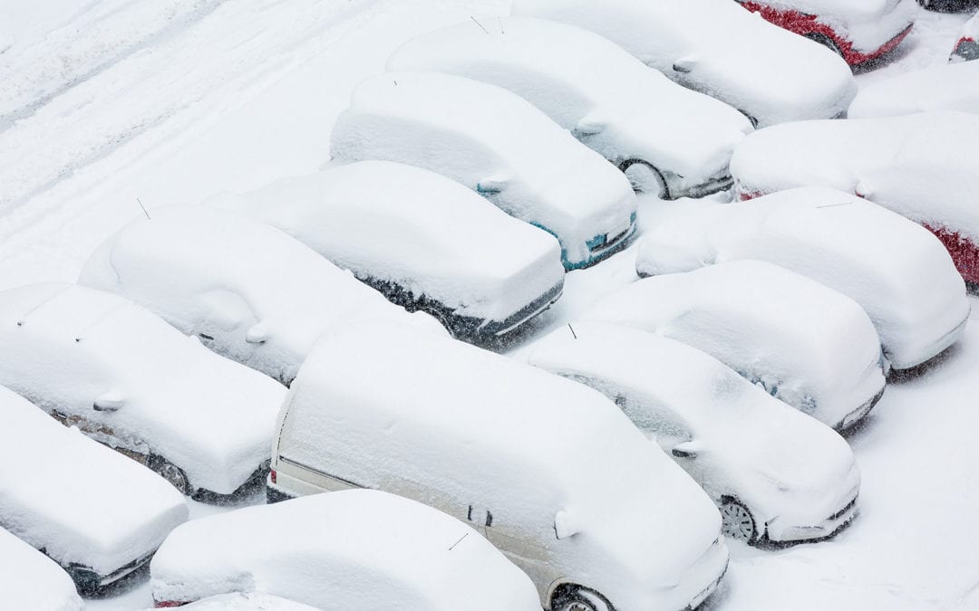 cars in a parking lot covered in snow