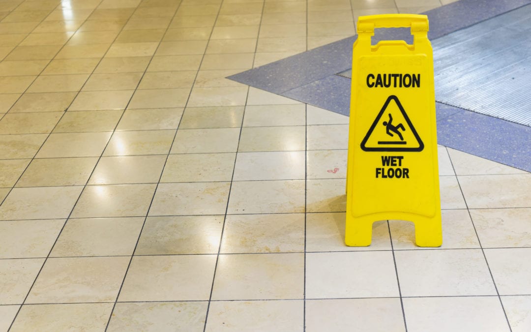 a tile floor with a Caution Wet Floor sign