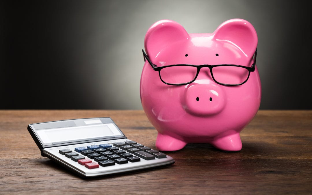 pink piggy bank next to calculator