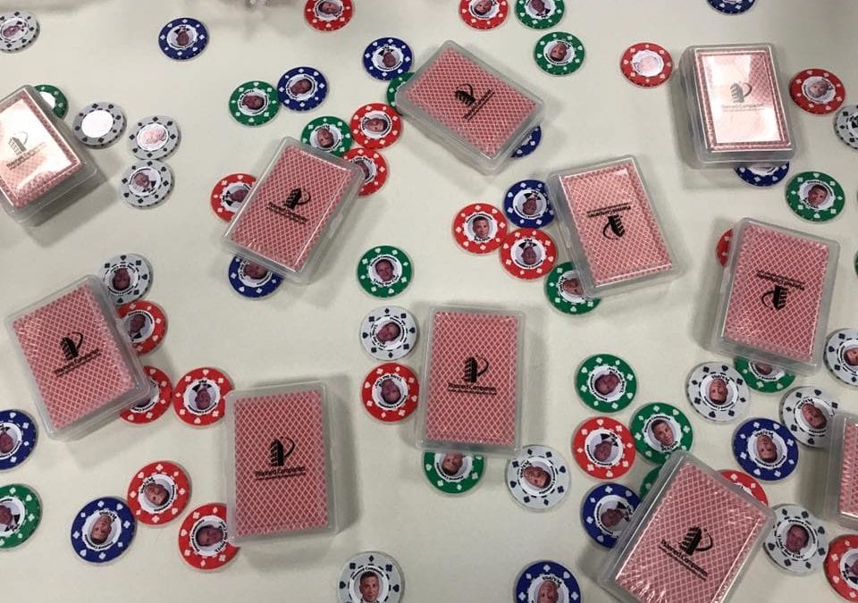 poker chips and decks of cards with the Planned Companies logo on the back of the cards