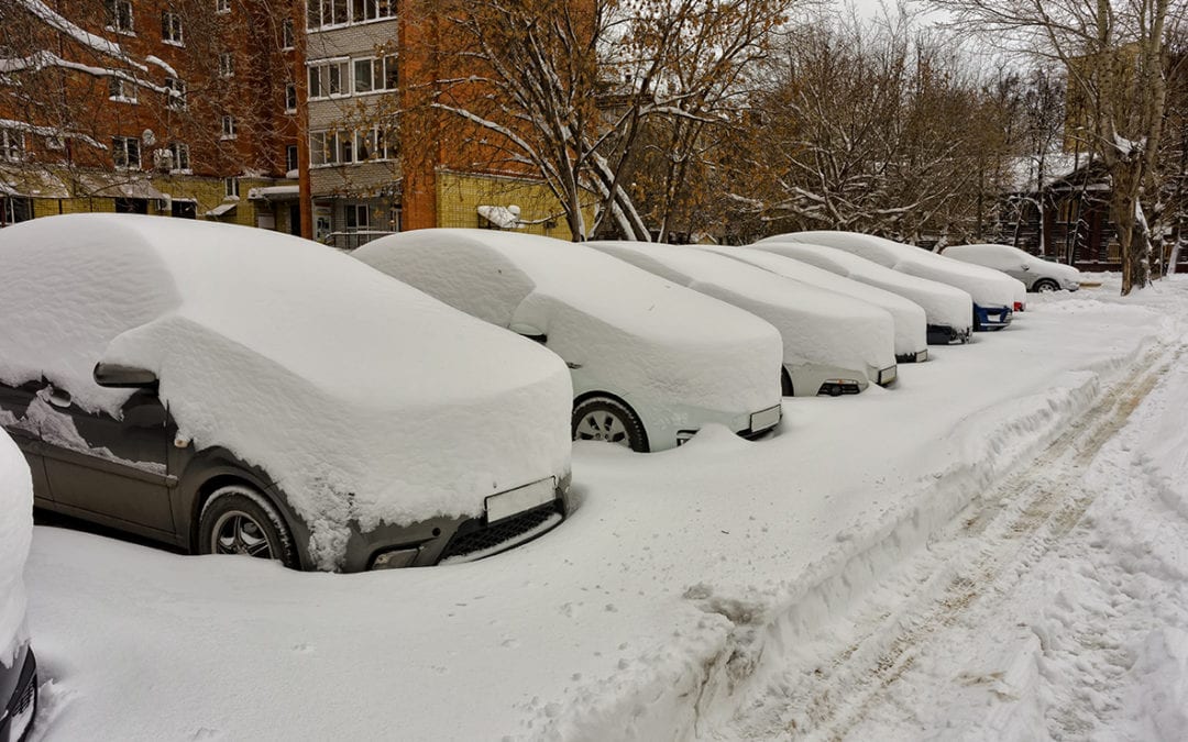 cars covered in snow in a parking lot