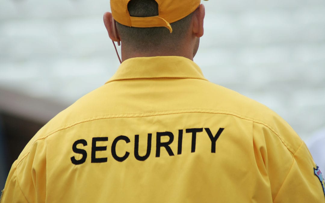 a man wearing a jacket with "security" on the back of it