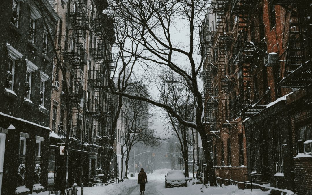 a snowy street with apartments on both sides